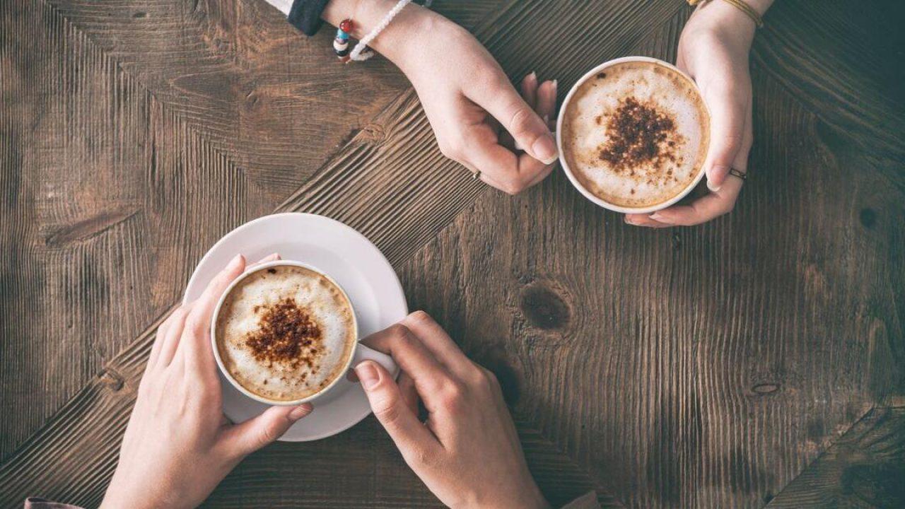 two people enjoying coffee on restored wooden table